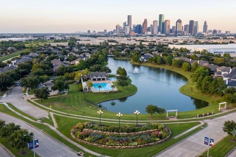 Affordable Plumbing Services area cover highlighting a Jersey Village, Texas neighborhood lake and the distant Houston skyline.