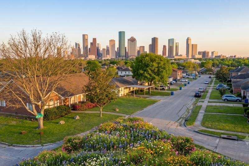 Affordable Plumbing Services area cover featuring a South Houston, Texas residential neighborhood with the downtown skyline in the background.