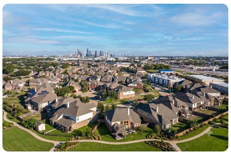 Aerial view of a Stafford, Texas neighborhood with the Houston skyline visible in the distance, serviced by Affordable Plumbing Services.