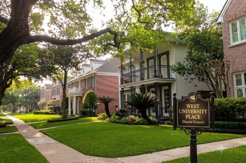 Tree-lined street in West University Place with luxury homes, serviced by Affordable Plumbing Services.