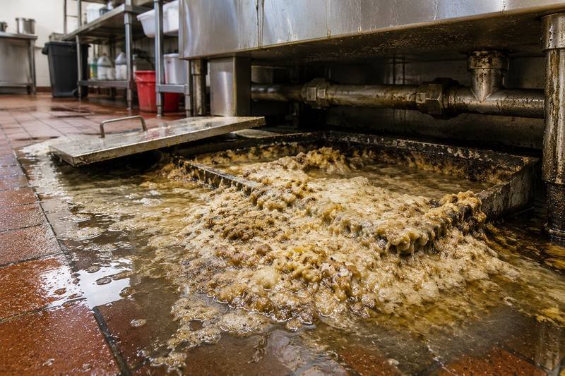 Commercial kitchen grease drain overflowing from severe grease buildup